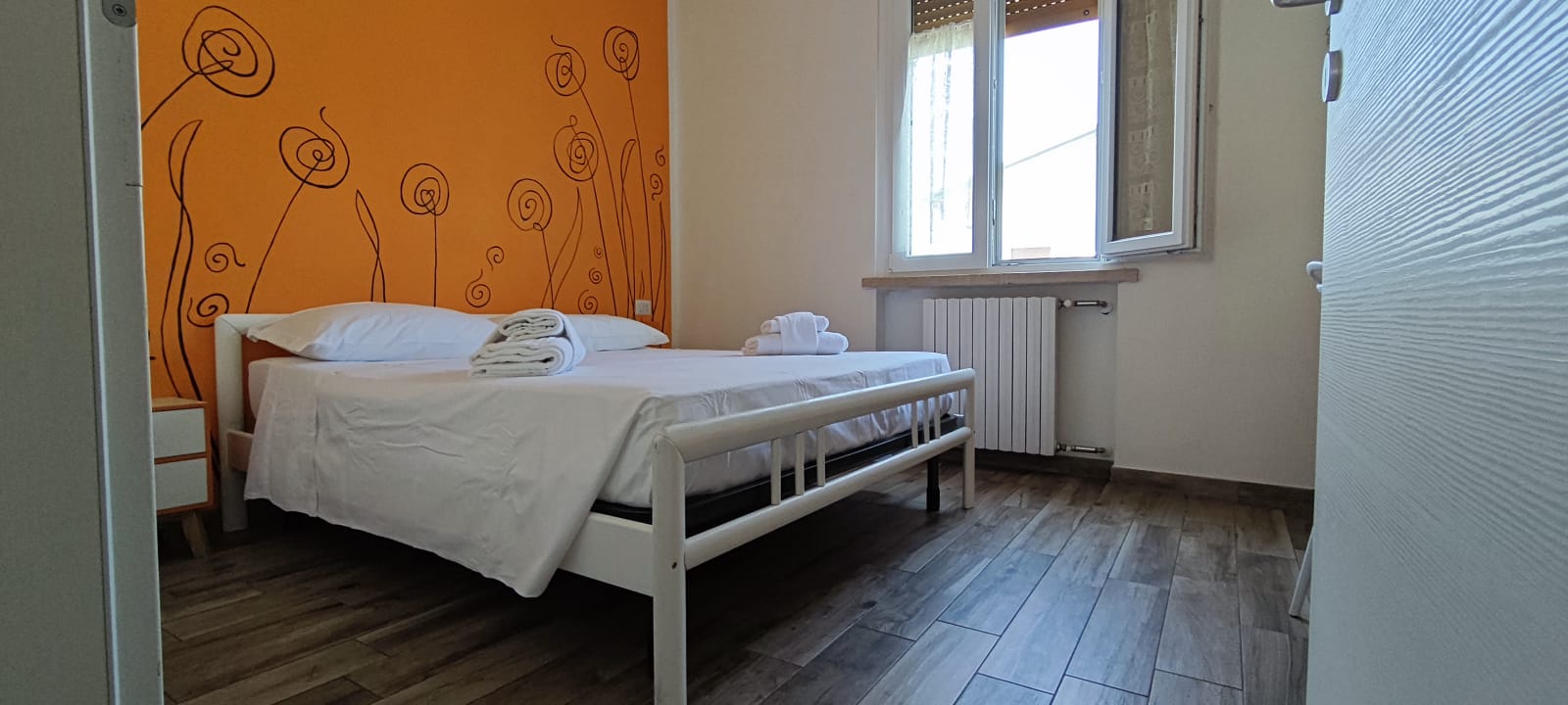 Apartment 3.Arancio — double bedroom with orange wall and window