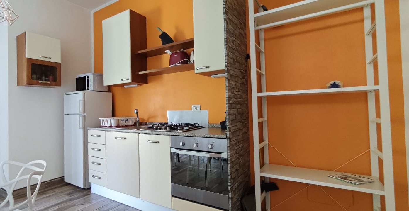Apartment 3.Arancio — fully equipped kitchen with column and open shelves