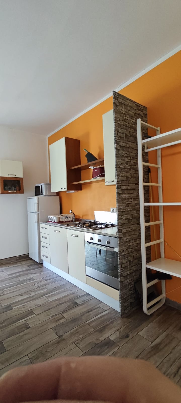 Apartment 3.Arancio — kitchen and open storage seen from the living area