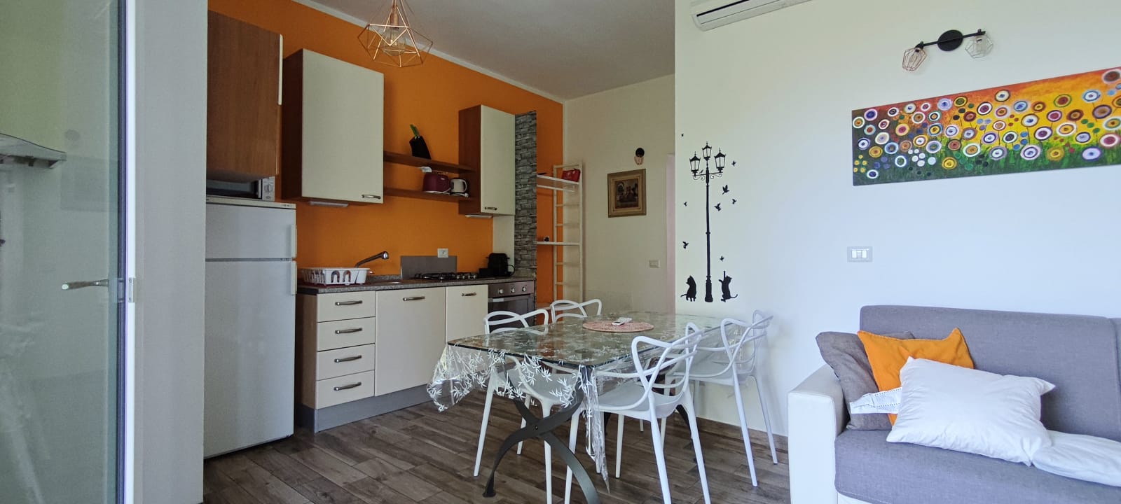 Apartment 3.Arancio — living area with kitchen, table and sofa