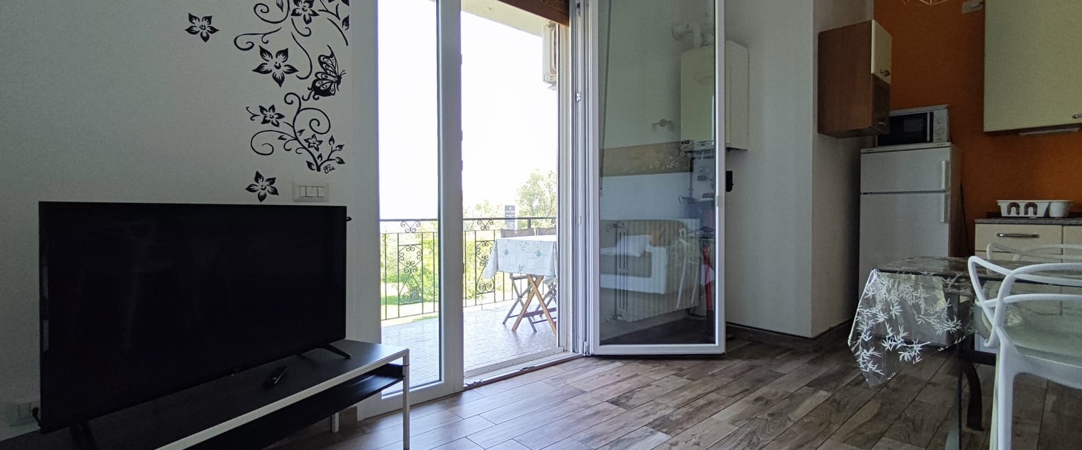 Apartment 3.Arancio — sitting room with Smart TV and French window onto the terrace
