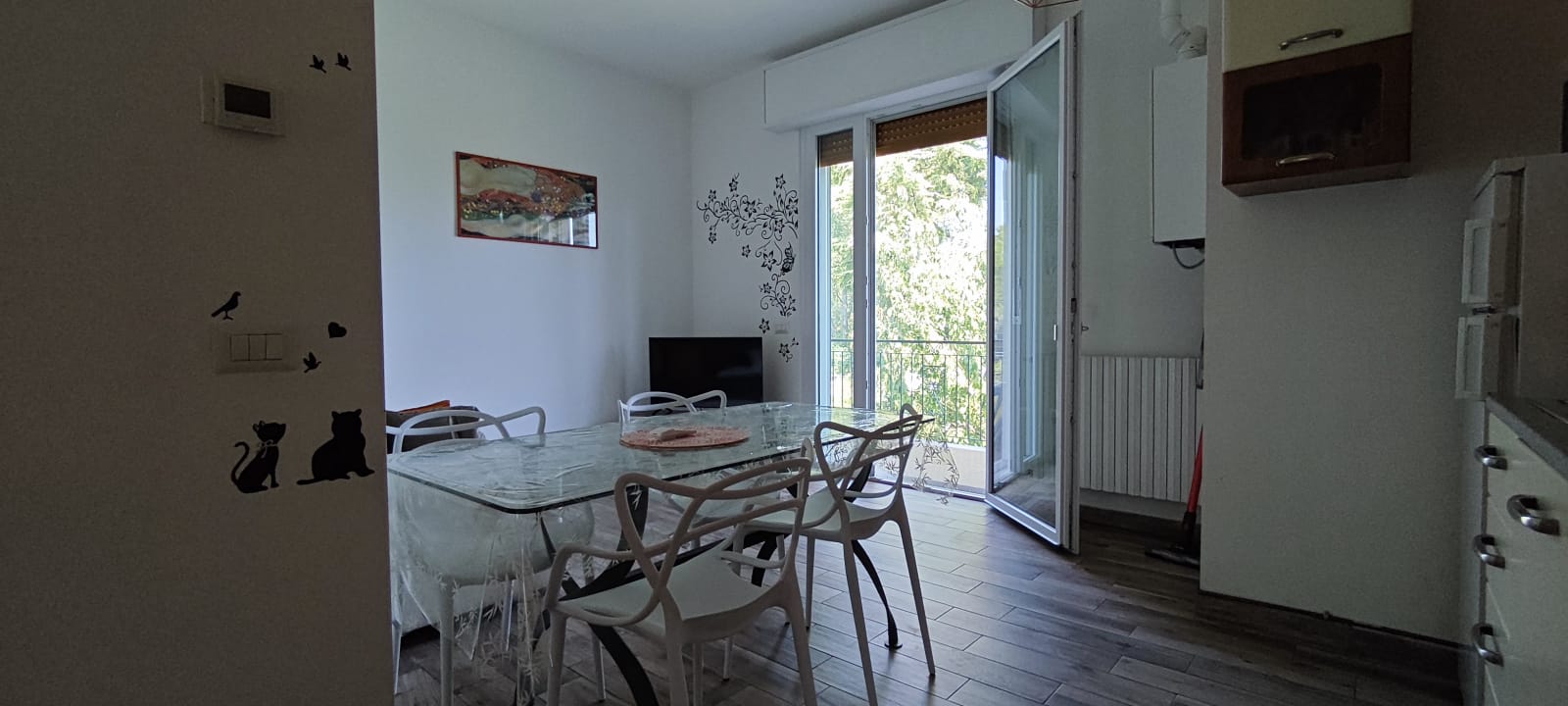 Apartment 3.Arancio — dining area and terrace access seen from the kitchen