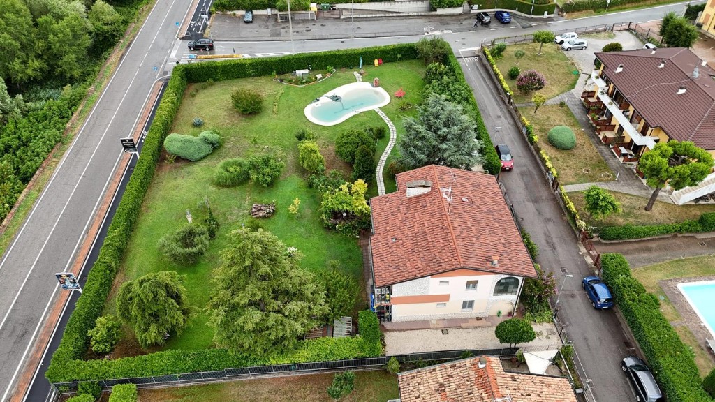 Veduta aerea del giardino recintato e della piscina naturale di GioiaSulGarda