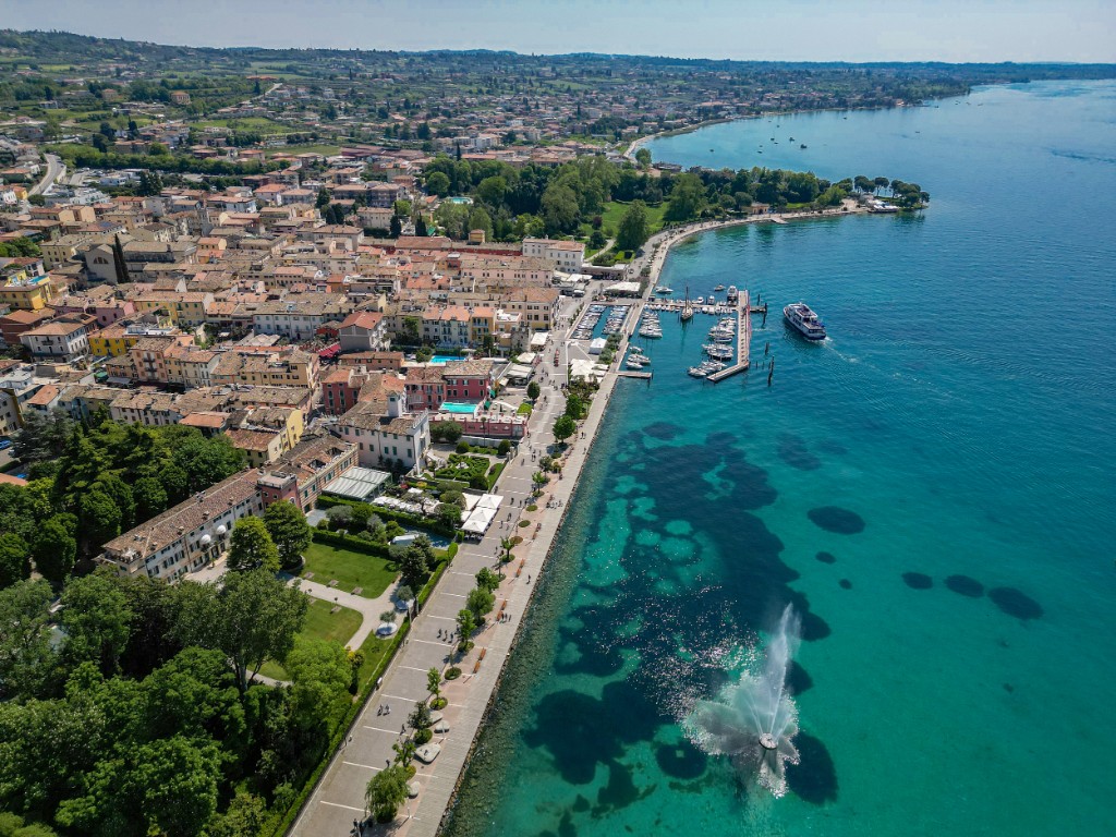 Aerial view of the Bardolino lakeside on Lake Garda, with harbour, promenade and tiled roofs