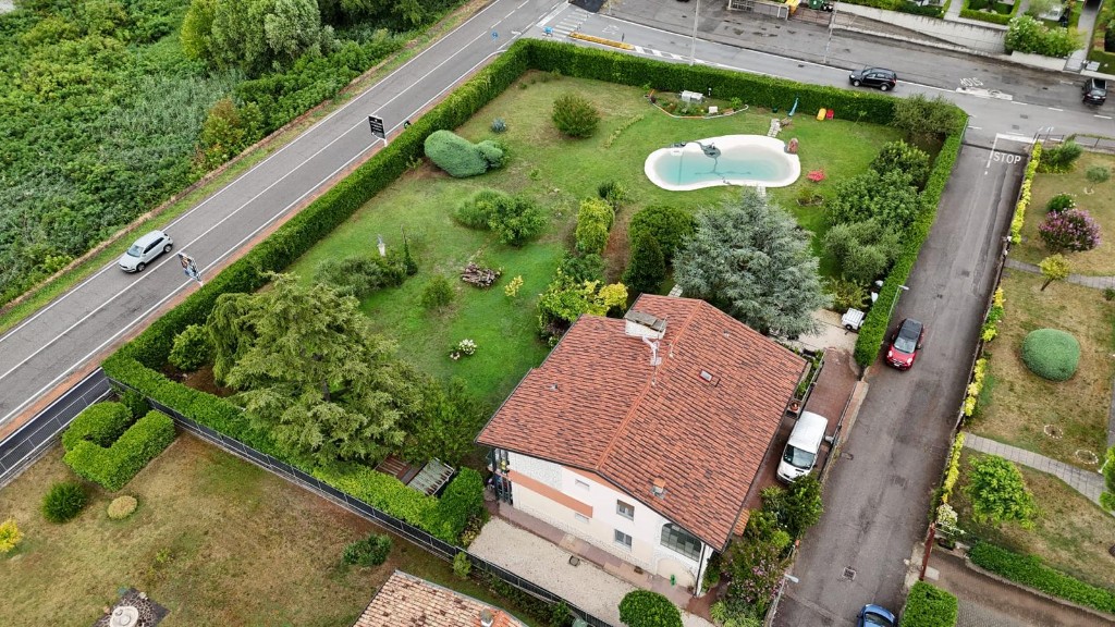Veduta aerea della proprietà GioiaSulGarda: tetto in coppi, giardino recintato con piscina a forma di rene e siepi