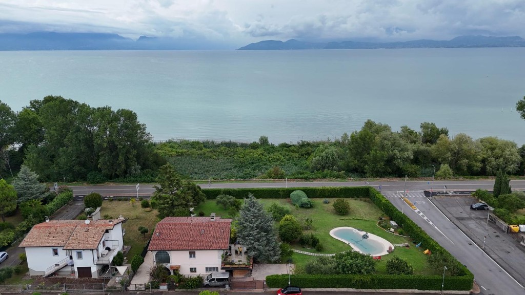 Veduta dall'alto di GioiaSulGarda: la casa con i tre appartamenti, il giardino con piscina e il Lago di Garda sullo sfondo