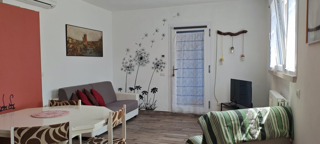 Apartament 2.Rosso — salon z sofami, stołem i Smart TV