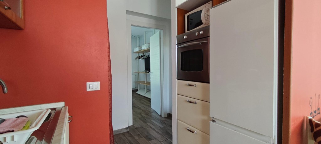 Apartament 2.Rosso — przejście między kuchnią a sypialnią z słupkiem